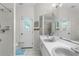 Bathroom featuring dual sinks, a walk-in shower, and an exterior door for outside access at 473 Tournament Dr, Spring Hill, FL 34608