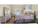 Bright bedroom featuring a queen-size bed with a floral comforter and wicker furniture at 473 Tournament Dr, Spring Hill, FL 34608