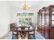 Formal dining room with elegant chandelier, hutch, dining table and chairs illuminated by natural light at 473 Tournament Dr, Spring Hill, FL 34608