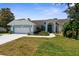 Charming single-story home with a well-manicured lawn, two-car garage, and a lovely blue trim at 473 Tournament Dr, Spring Hill, FL 34608