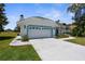 Charming single-story home with a well-manicured lawn, two-car garage, and a lovely blue trim at 473 Tournament Dr, Spring Hill, FL 34608