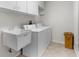 Functional laundry room with a utility sink, washer, dryer, and storage for household tasks at 473 Tournament Dr, Spring Hill, FL 34608