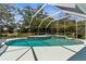 Enclosed in a screen, the pool and spa feature crisp, blue water with an expansive yard view at 473 Tournament Dr, Spring Hill, FL 34608