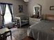Well-lit bedroom with hardwood floors, a crib, bed, and colorful rug at 5045 Musselshell Dr, New Port Richey, FL 34655