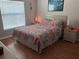 Comfortable bedroom featuring a queen bed, natural light, and wood-look floors at 5045 Musselshell Dr, New Port Richey, FL 34655