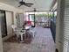 Covered brick patio with ceiling fans, table and chairs, ideal for outdoor dining at 5045 Musselshell Dr, New Port Richey, FL 34655