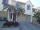 Charming townhome with attached garage and well-maintained landscaping featuring lovely palm trees in a desirable community at 545 Walden Ct, Dunedin, FL 34698