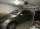 A modern car is parked inside garage with storage shelves and an automatic door opener installed at 545 Walden Ct, Dunedin, FL 34698
