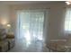 Bright living room with large sliding glass doors and neutral tile flooring at 545 Walden Ct, Dunedin, FL 34698