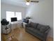 Bright room with a gray couch, desk, computer setup, and plenty of light from the window blinds at 545 Walden Ct, Dunedin, FL 34698