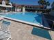 Community pool with clear blue water, patio furniture, and landscaping at 545 Walden Ct, Dunedin, FL 34698