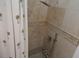 Shower stall tiled with stone and decorative accents, complete with a palm tree design shower curtain at 545 Walden Ct, Dunedin, FL 34698