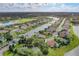 Aerial view of the community with homes, a central lake, and green spaces at 6109 Japonica Ct, New Port Richey, FL 34655