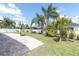 Spacious backyard with brick path, manicured lawn, white fence and lush palm trees at 6109 Japonica Ct, New Port Richey, FL 34655