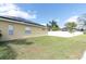 Side view of a backyard featuring a grassy area, complemented by a white fence for privacy and security at 6109 Japonica Ct, New Port Richey, FL 34655