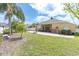 A large backyard showcasing a well-maintained lawn, palm trees, and a cozy patio area perfect for relaxing at 6109 Japonica Ct, New Port Richey, FL 34655