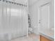 Bright bathroom featuring a toilet, shower, and door with privacy blinds at 6109 Japonica Ct, New Port Richey, FL 34655