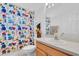 Well-lit bathroom featuring a sink, a colorful shower curtain, and a mirror at 6109 Japonica Ct, New Port Richey, FL 34655