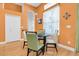 Cozy dining area with modern table, stylish chairs, and bright orange wall at 6109 Japonica Ct, New Port Richey, FL 34655