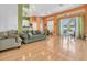 Inviting living room with orange accent wall, sofa, and sliding glass doors to the patio at 6109 Japonica Ct, New Port Richey, FL 34655