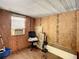 Unfinished room featuring natural wood walls, window, wood-look flooring, and potential for customization at 6507 Ginny Dr, Port Richey, FL 34668