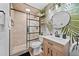 Modern bathroom with a walk-in shower, stylish vanity, and unique palm wallpaper at 7101 N 18Th St, Tampa, FL 33610