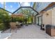 Enjoy outdoor dining on a brick patio in this screened-in porch with a table and seating at 7101 N 18Th St, Tampa, FL 33610