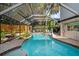 Beautiful private pool surrounded by lush landscaping, featuring a screened enclosure for year-round enjoyment at 7101 N 18Th St, Tampa, FL 33610