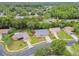 Aerial shot of a home nestled in a lush neighborhood with mature trees and well-maintained landscaping at 7427 Baltusrol Dr, New Port Richey, FL 34654