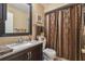 Bathroom view showcasing vanity with granite countertop, dark wood cabinets, and decorative patterned shower curtain at 7427 Baltusrol Dr, New Port Richey, FL 34654