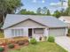 Charming single-story home featuring a well-manicured lawn, stone accents, and a two-car garage at 7427 Baltusrol Dr, New Port Richey, FL 34654