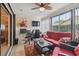 Sunroom with red cushioned seating, fan, and large windows, perfect for a relaxing workspace at 7427 Baltusrol Dr, New Port Richey, FL 34654