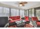 Bright sunroom with a ceiling fan, large windows, and cozy furniture, ideal for relaxation at 7427 Baltusrol Dr, New Port Richey, FL 34654