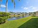 Backyard view of a pond surrounded by houses and lush greenery, perfect for relaxation at 7427 Wimpole Dr # 7427, New Port Richey, FL 34655