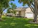 Single-story home with two-car garage, well-manicured lawn, and mature trees at 7427 Wimpole Dr # 7427, New Port Richey, FL 34655