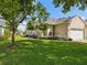 Well-manicured lawn surrounds this single-story home with lush landscaping and a two-car garage at 7427 Wimpole Dr # 7427, New Port Richey, FL 34655