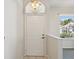 Bright foyer featuring tile flooring, white door, decorative light, and a glimpse of the living area at 7427 Wimpole Dr # 7427, New Port Richey, FL 34655