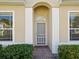 Inviting front entrance with decorative archway, manicured bushes, and tiled walkway at 7427 Wimpole Dr # 7427, New Port Richey, FL 34655