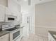 White kitchen featuring a full suite of appliances and tile flooring at 7427 Wimpole Dr # 7427, New Port Richey, FL 34655