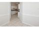 Hallway view of a white kitchen with tile flooring at 7427 Wimpole Dr # 7427, New Port Richey, FL 34655