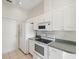 Bright kitchen featuring white appliances, cabinets, and tile flooring at 7427 Wimpole Dr # 7427, New Port Richey, FL 34655