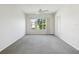 The carpeted living room is well-lit by a large window and ceiling fan, creating a comfortable ambiance at 7427 Wimpole Dr # 7427, New Port Richey, FL 34655