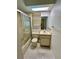Bright bathroom with a shower, skylight, vanity, and tiled floor, offering functionality at 7444 Candlelight Ct, New Port Richey, FL 34652
