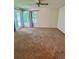 Bright bedroom with a ceiling fan, carpet and sliding glass door to the exterior at 7444 Candlelight Ct, New Port Richey, FL 34652