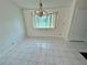 Dining area featuring tiled floors, a bay window, and a classic chandelier at 7444 Candlelight Ct, New Port Richey, FL 34652