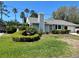 Charming single-story home featuring a well-manicured lawn and lush landscaping with palm trees and a winding walkway at 7444 Candlelight Ct, New Port Richey, FL 34652