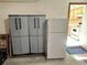 Garage interior with storage cabinets and refrigerator, leading to kitchen at 7444 Candlelight Ct, New Port Richey, FL 34652