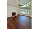 Cozy living room featuring a fireplace, wood floors, and large windows for natural light at 7444 Candlelight Ct, New Port Richey, FL 34652