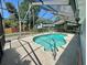 A sparkling private pool is enclosed within a screen, perfect for relaxation and recreation in a sunny backyard at 7444 Candlelight Ct, New Port Richey, FL 34652