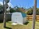 Durable, modern white storage shed with a blue roof, perfect for secure storage in your backyard at 7444 Candlelight Ct, New Port Richey, FL 34652